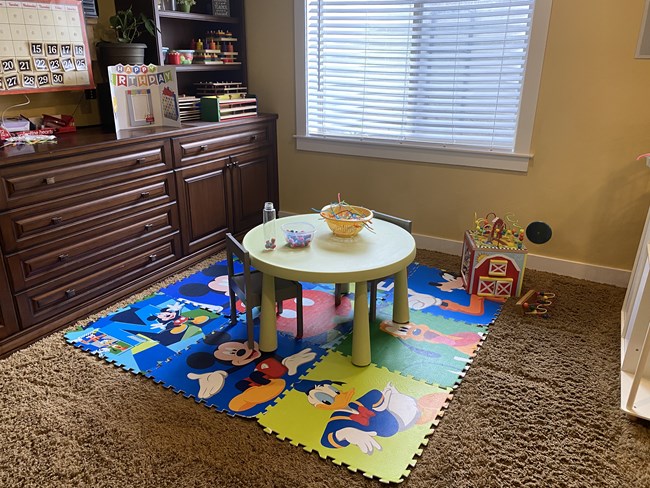 Round snack table on a colorful character rug