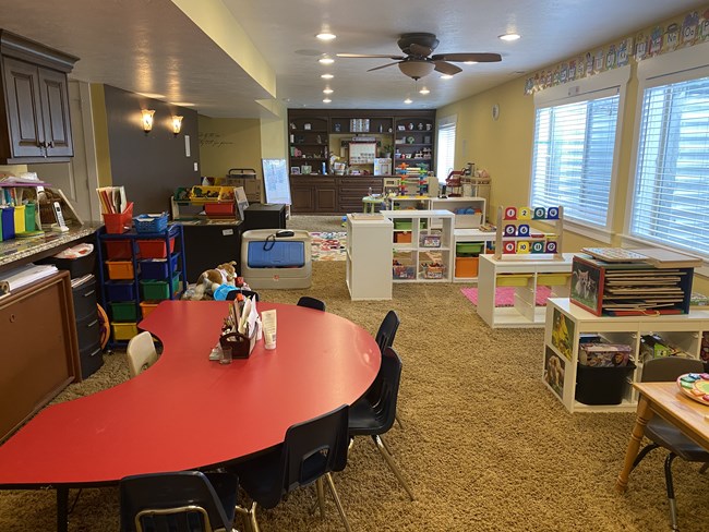 Main group play room with tables and shelving