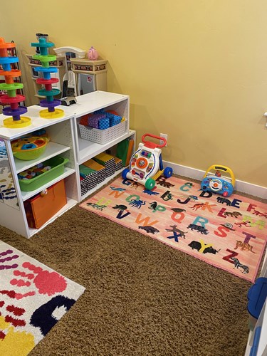 Alphabet rug with shape-sorting toys and a toddler activity table