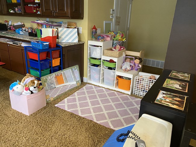 Quiet corner with dolls, stuffed animals, and storage bins