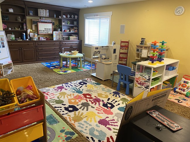 Group room with handprint rug and play kitchen